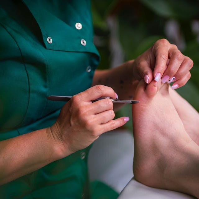 Zbliżenie na stopę w takcie pedicure wykonywanym w salonie kosmetycznym Health & beauty