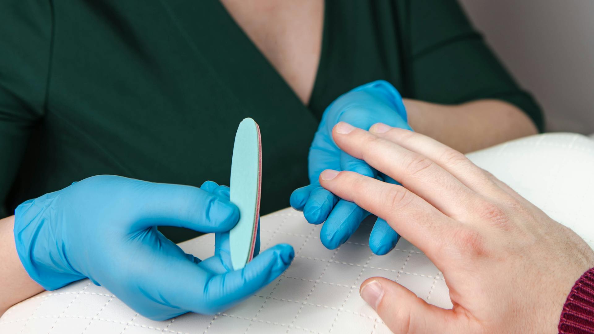 manicurzystka w trakcie wykonywania manicure meskiego