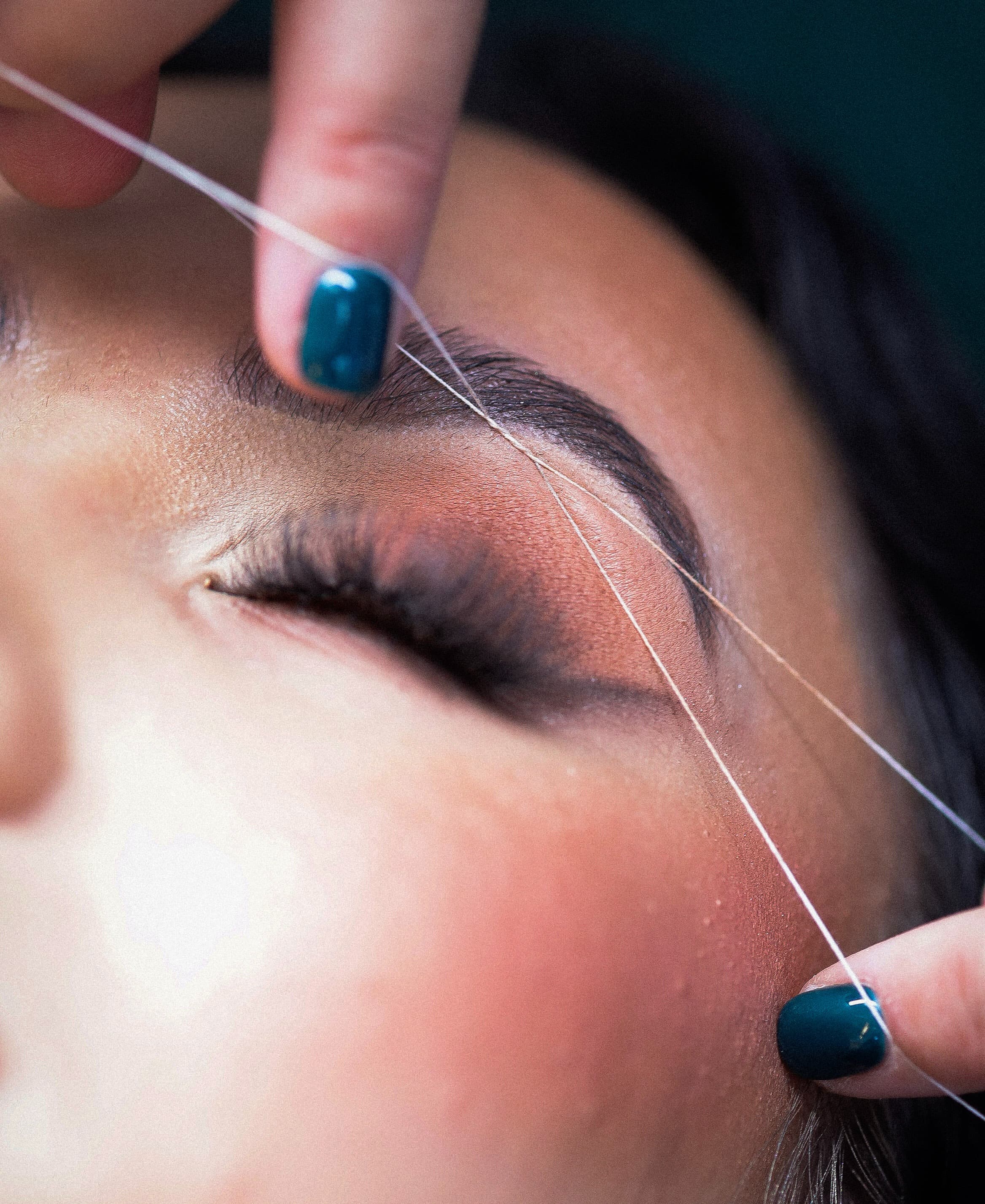 w trakcie nitkowania brwi w salonie urody w Krakowie