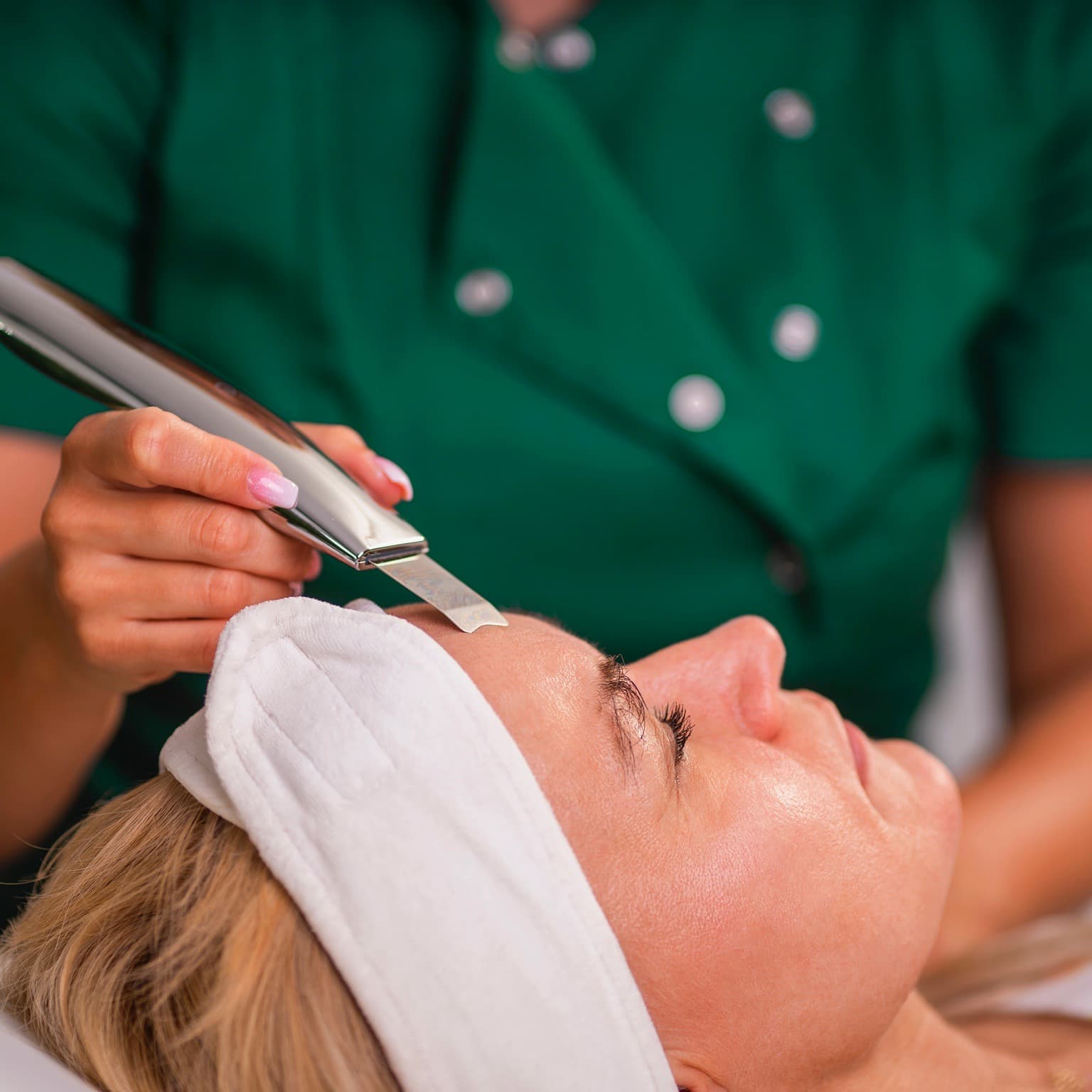 kosmetyczka w trakcie oczyszczania twarzy zabiegiem peeling kawitacyjny w salonie kosmetycznym Health and beauty w Krakowie