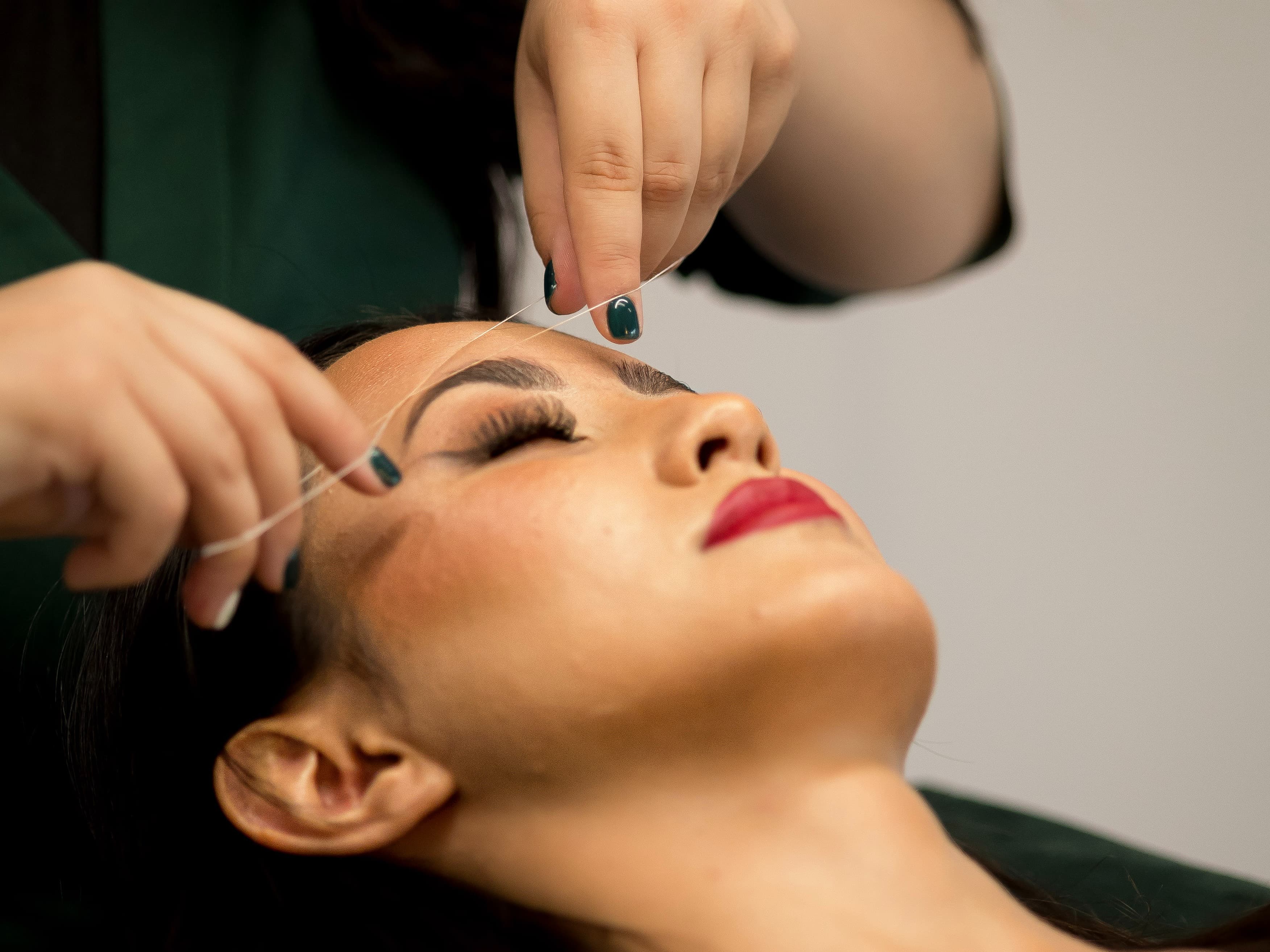 w trakcie zabiegu nitkowanie brwi w salonie piękności w Krakowie