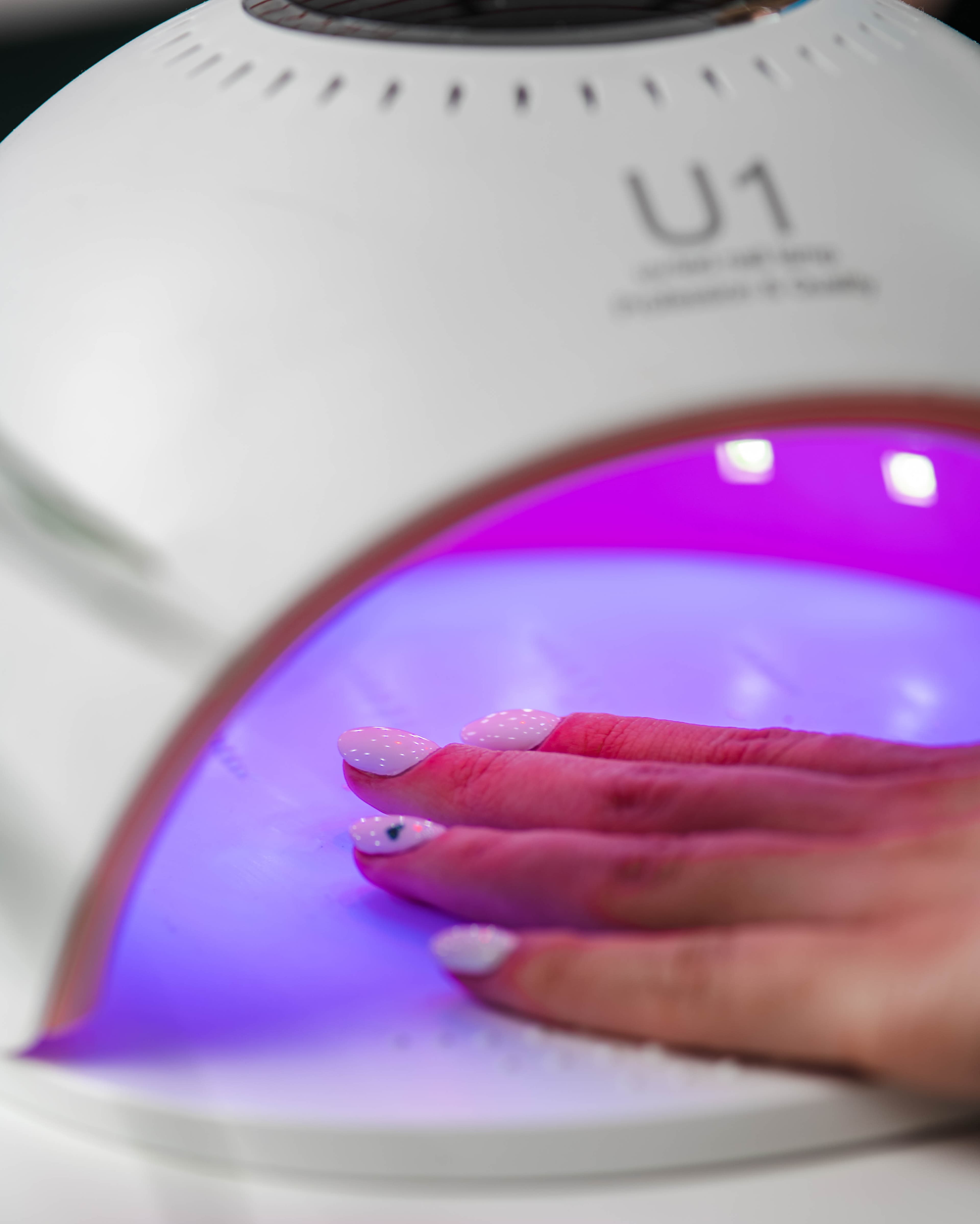 utwardzanie wartwy lakieru pod lampą UV podczas manicure hybrydowego zbliżenie